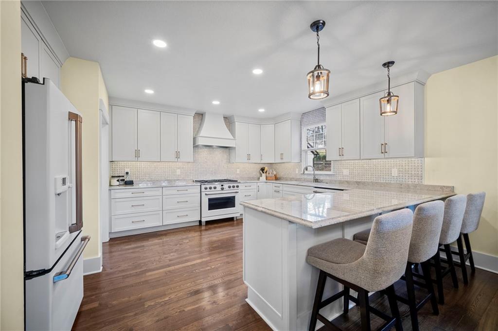 3252 Comanche Road Upper St. Clair, PA 15241 - Photo 10 of 50 a kitchen with stainless steel appliances kitchen island granite countertop a table chairs refrigerator and wooden cabinets