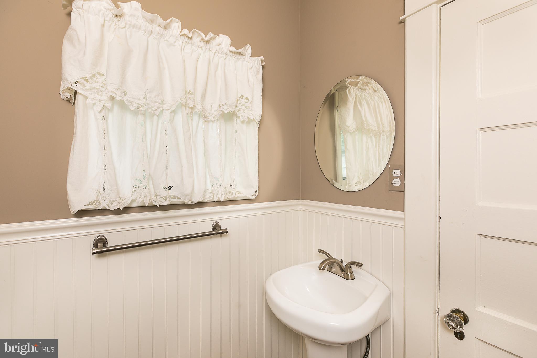 425 Westgate Road Baltimore, MD 21229 - Photo 17 of 32 a bathroom with a sink a mirror and a window