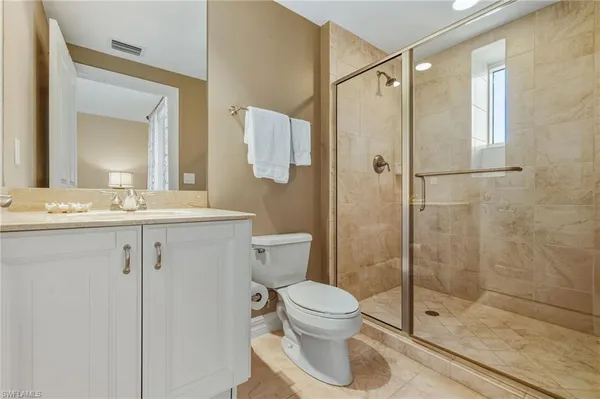 a bathroom with a shower sink mirror and toilet