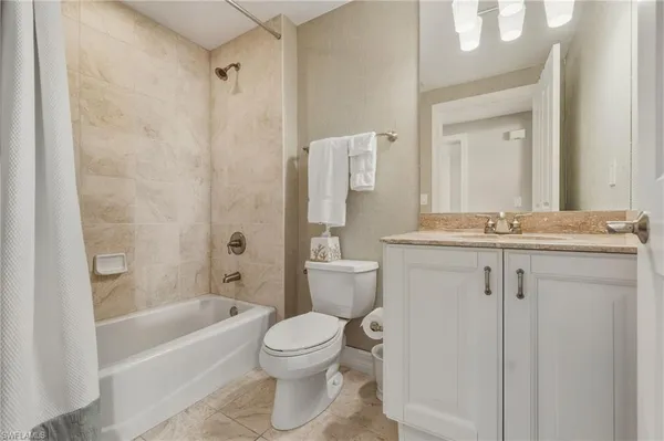 a bathroom with a granite countertop sink a toilet and shower