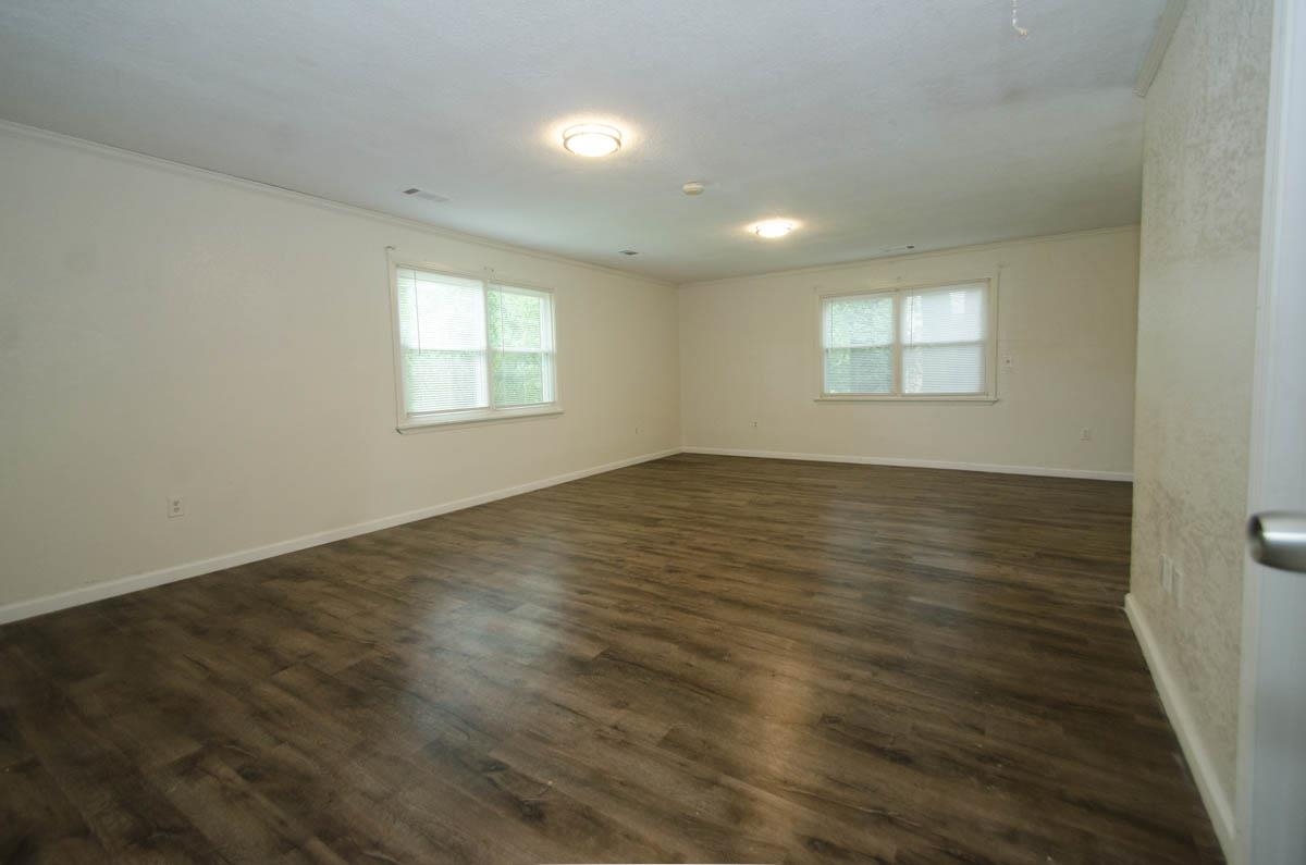 35 Dee Road Somerville, TN 38068 - Photo 12 of 15 Empty room featuring ornamental molding, plenty of natural light, and dark wood-type flooring