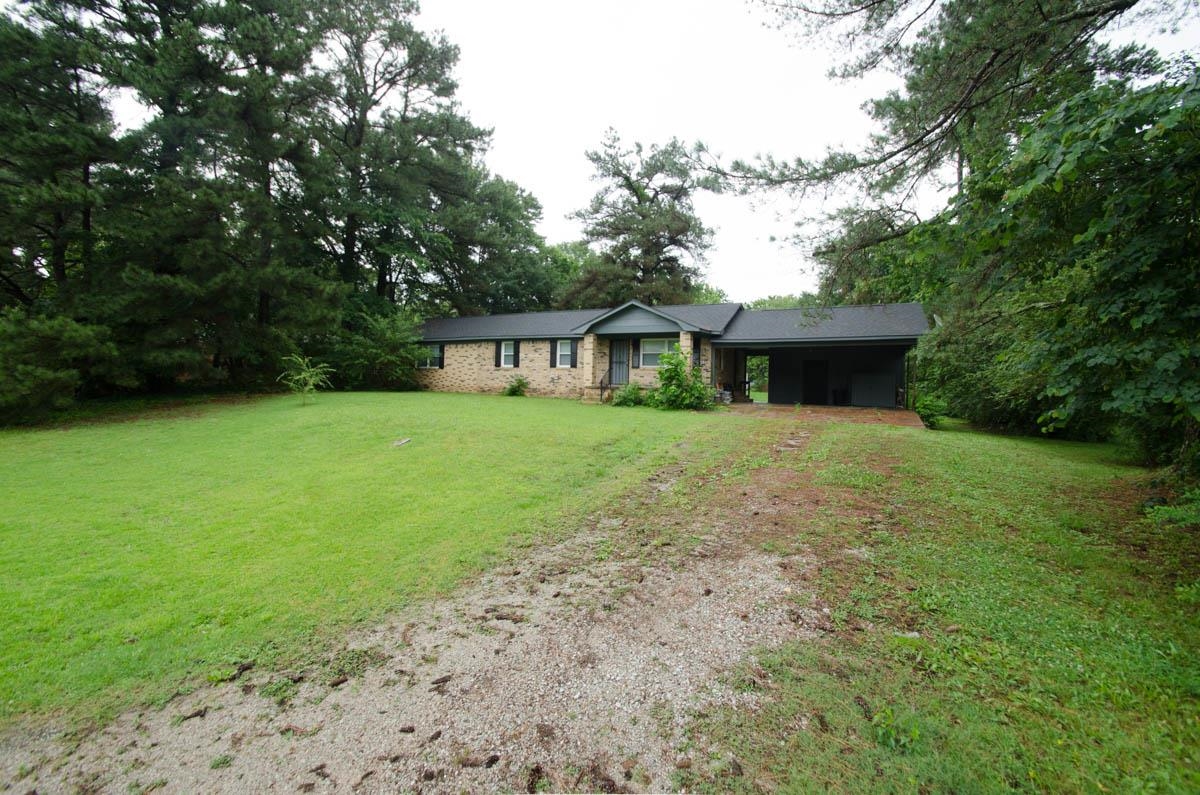 35 Dee Road Somerville, TN 38068 - Photo 2 of 15 View of front of property featuring a carport, driveway, a front yard, and stone siding
