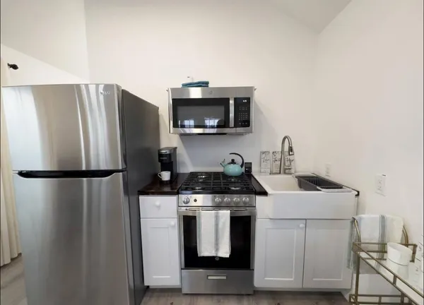a kitchen with a stove top oven and refrigerator
