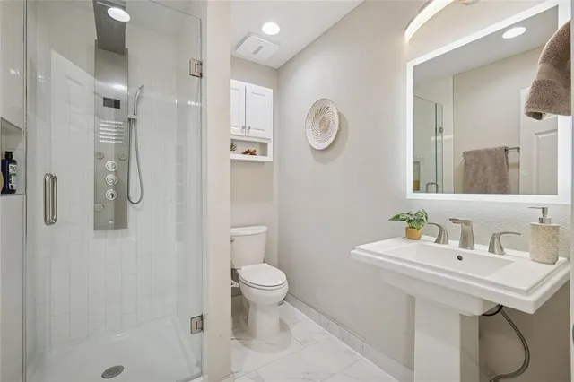 a bathroom with a sink toilet and shower