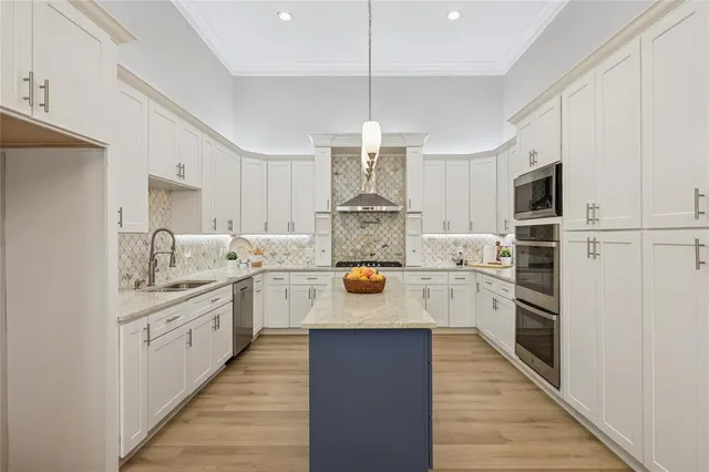 a kitchen with stainless steel appliances a refrigerator sink and white cabinets