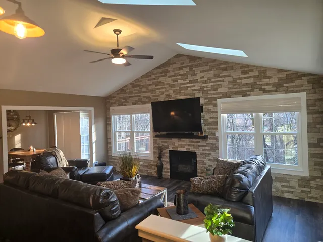 a living room with furniture a fireplace and a flat screen tv