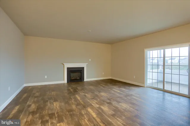 a view of an empty room with a window and fireplace