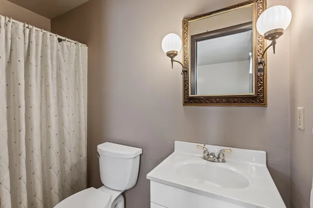 a bathroom with a toilet a sink and mirror