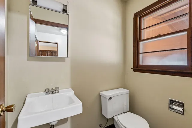 a bathroom with a toilet sink and mirror