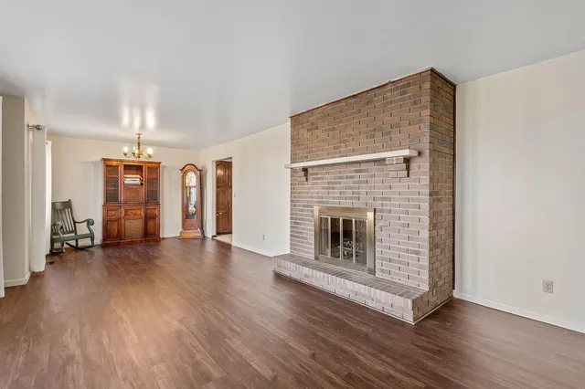 a view of a livingroom with wooden floor and a fireplace