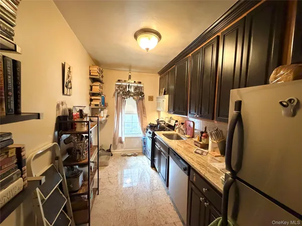 a kitchen with kitchen island granite countertop a refrigerator stove and sink