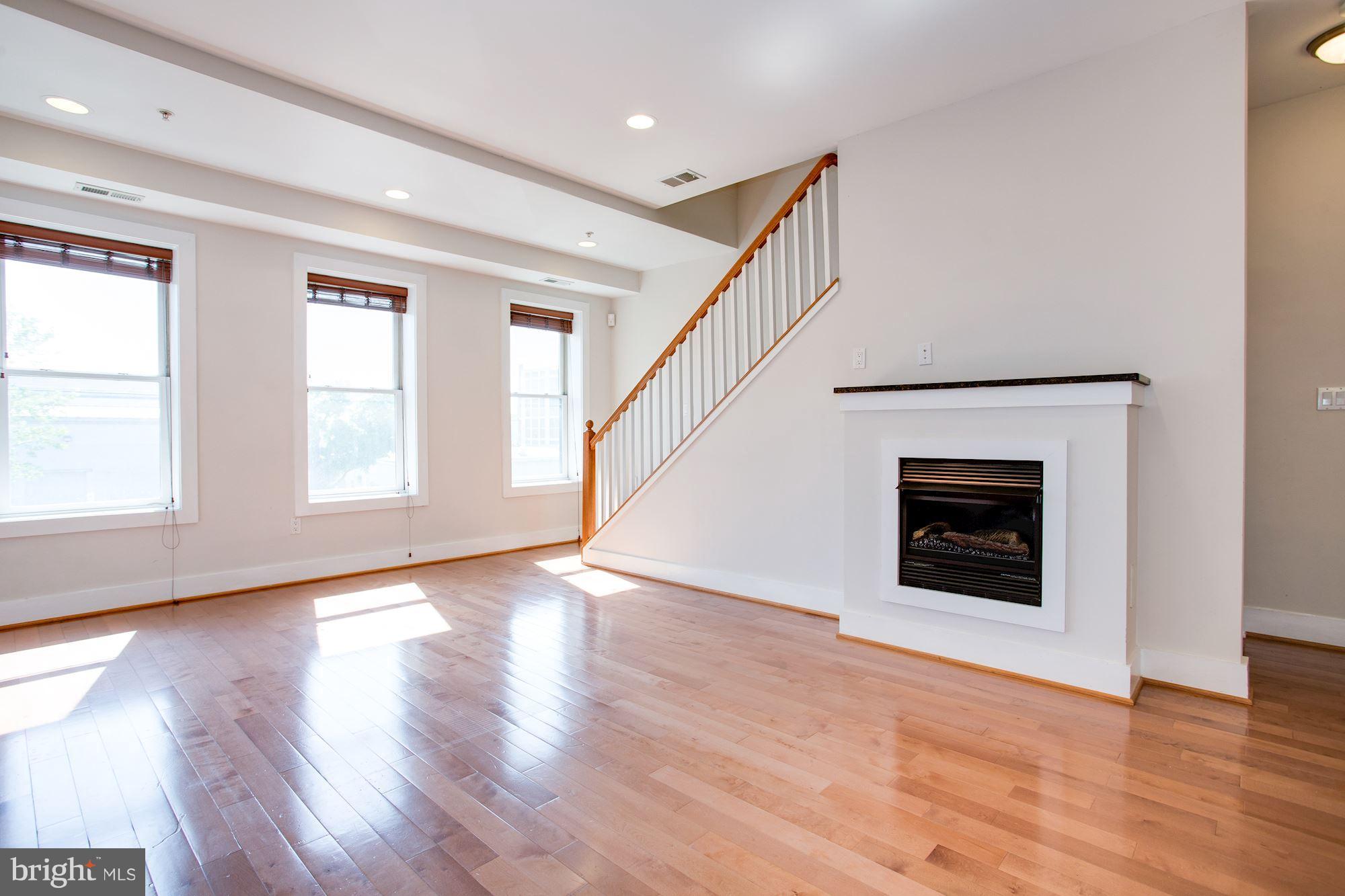 1912 4th Street Northeast, Unit 2 Washington, DC 20002 - Photo 4 of 23 a view of an empty room with wooden floor fireplace and a window