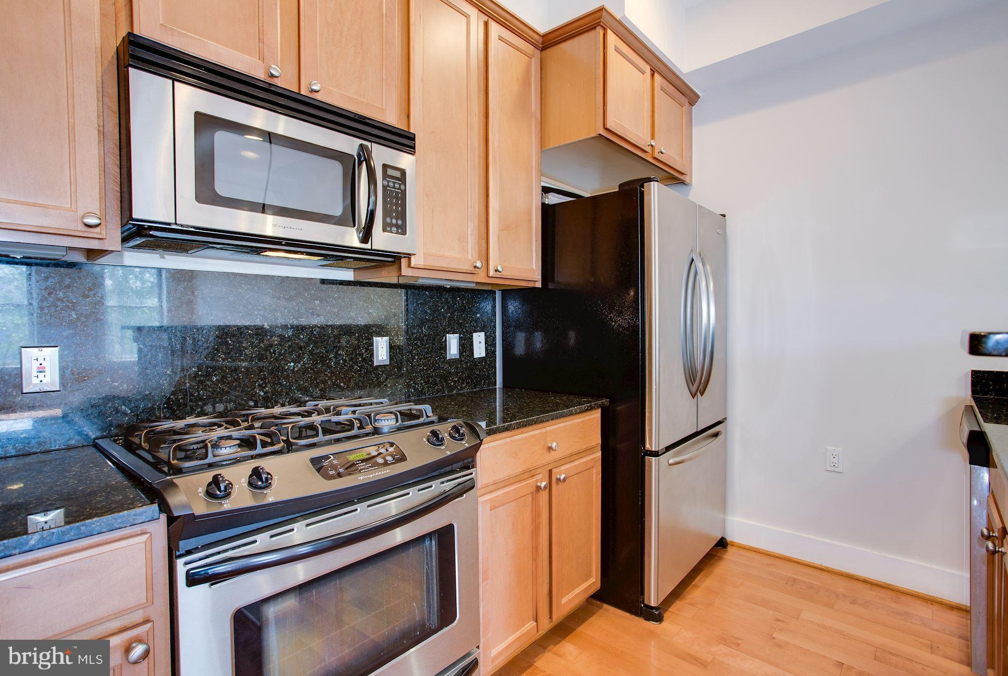 1912 4th Street Northeast, Unit 2 Washington, DC 20002 - Photo 7 of 23 a kitchen with stainless steel appliances granite countertop a stove microwave and refrigerator