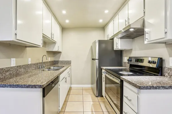 a kitchen with stainless steel appliances granite countertop a sink stove and refrigerator