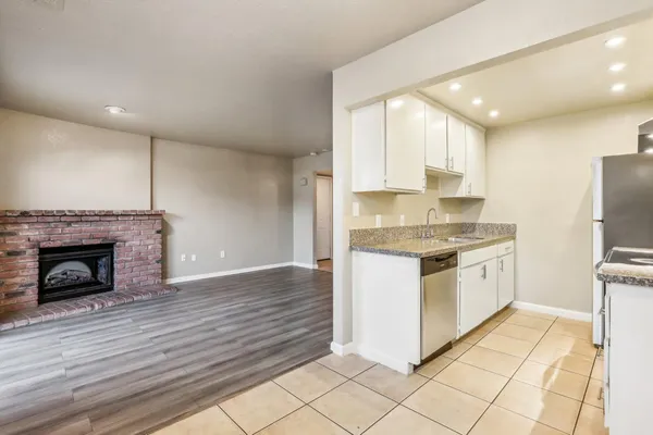 a kitchen with granite countertop a stove top oven and cabinets