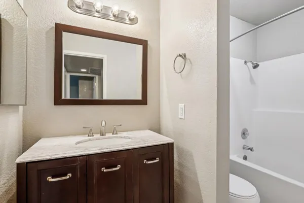 a bathroom with a granite countertop sink toilet and shower