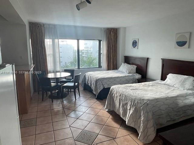 6345 Collins Avenue, Unit 614 Miami Beach, FL 33141 - Photo 7 of 12 a spacious bedroom with a bed and a table in it