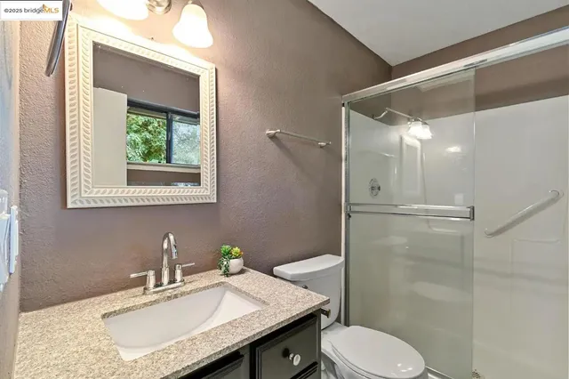 a bathroom with a granite countertop toilet sink and shower