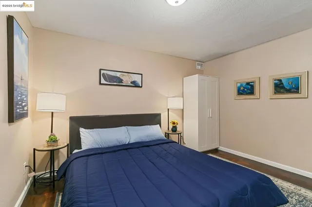 a bedroom with a bed and wooden floor