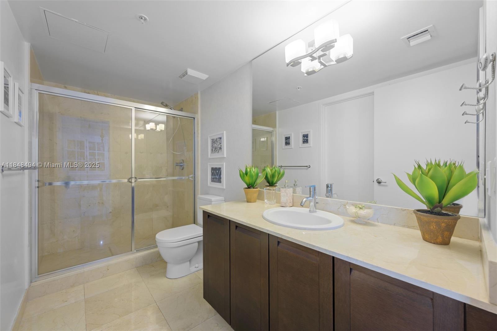 150 Sunny Isles Boulevard, Unit TH301 Sunny Isles Beach, FL 33160 - Photo 14 of 25 a bathroom with a sink a toilet and a shower