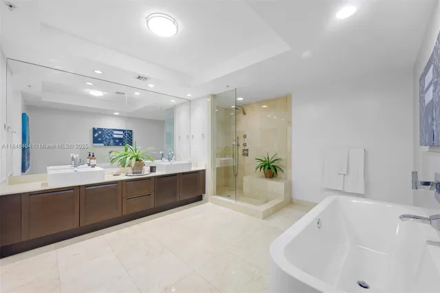 a spacious bathroom with a tub a sink and mirror