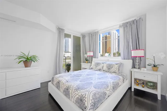 a bedroom with a bed and a potted plant on the dresser