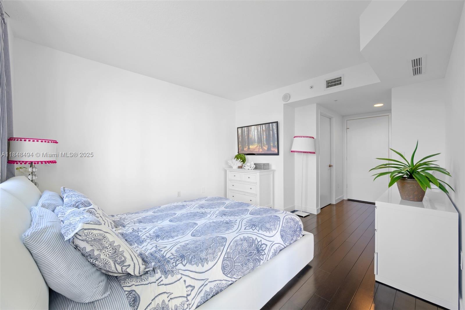 150 Sunny Isles Boulevard, Unit TH301 Sunny Isles Beach, FL 33160 - Photo 22 of 25 a bedroom with a bed and a potted plant on the dresser