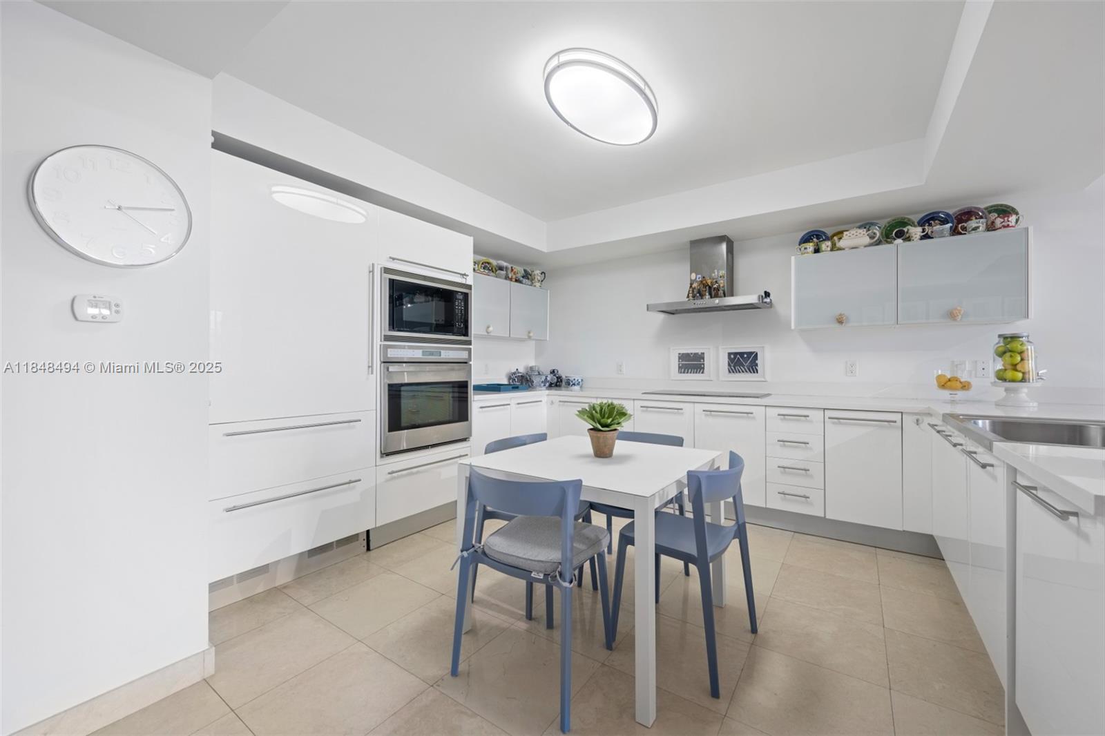 150 Sunny Isles Boulevard, Unit TH301 Sunny Isles Beach, FL 33160 - Photo 7 of 25 a kitchen with a table and chairs in it
