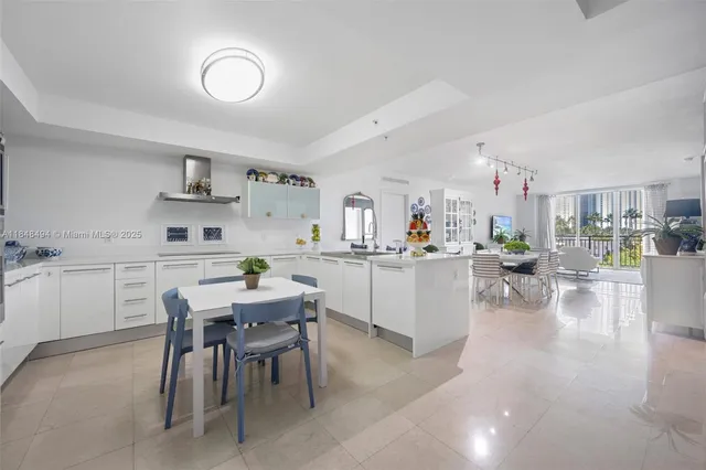 a kitchen with a dining table chairs and white cabinets