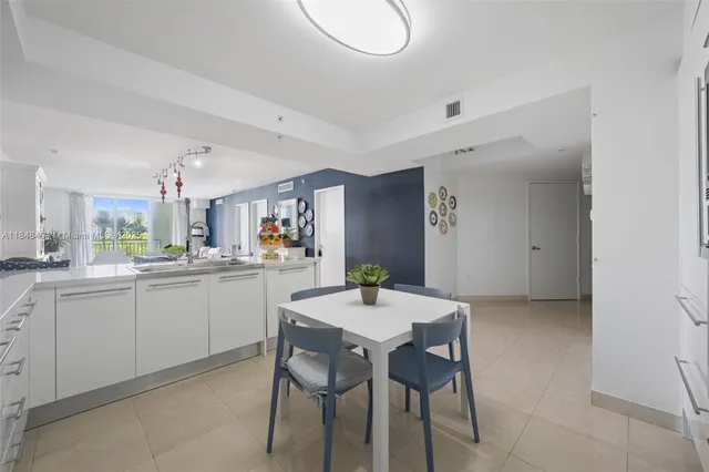 a kitchen with a dining table chairs and white cabinets