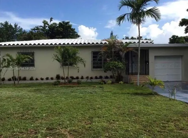 a view of a backyard with plants and palm trees