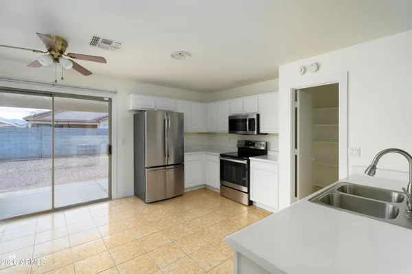 a kitchen with a refrigerator a microwave a stove and cabinets