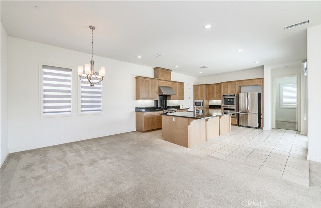 105 Bryce Run Lake Forest, CA 92630 - Photo 11 of 36 a view of kitchen with stainless steel appliances granite countertop a stove top oven a sink and a chandelier