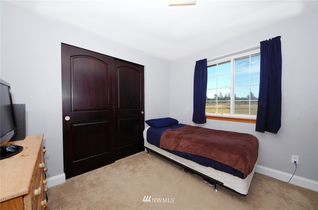 18131 Case Road Southwest Rochester, WA 98579 - Photo 12 of 16 a bedroom with a bed and a flat tv screen on a dresser