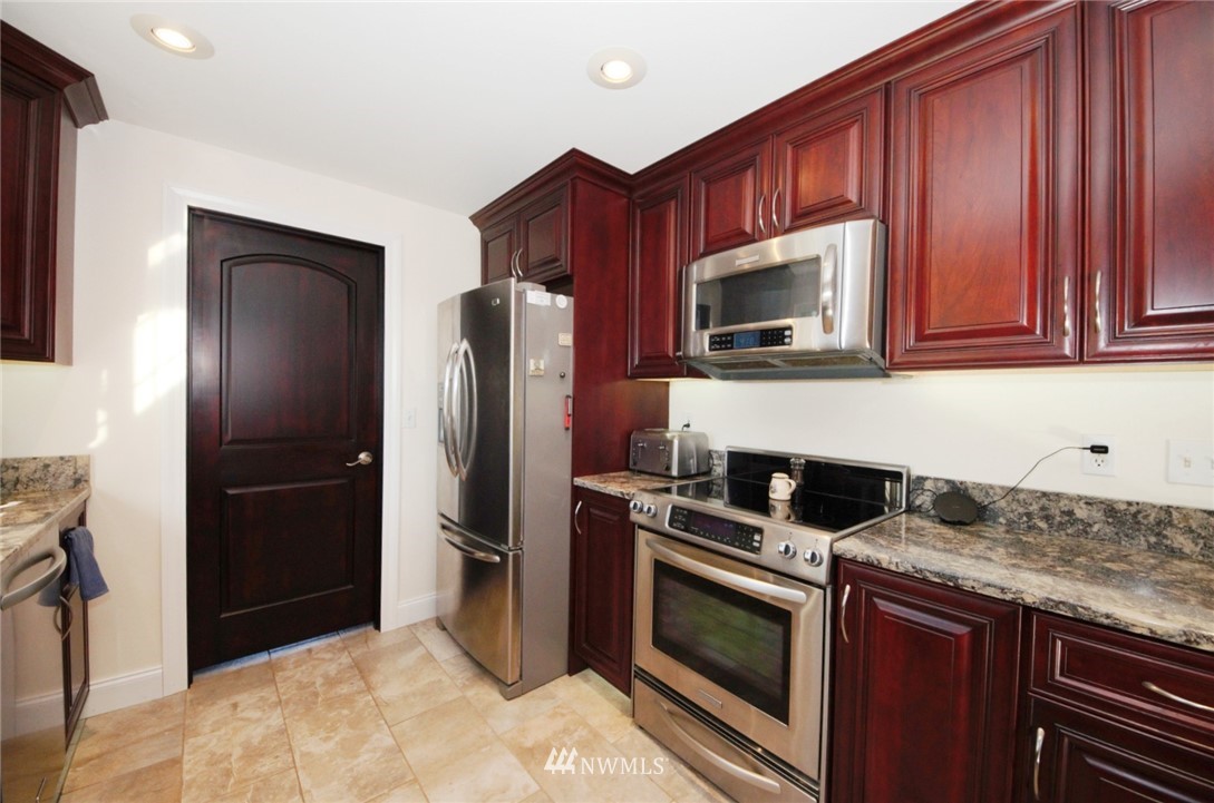 18131 Case Road Southwest Rochester, WA 98579 - Photo 5 of 16 a kitchen with granite countertop wooden cabinets and stainless steel appliances