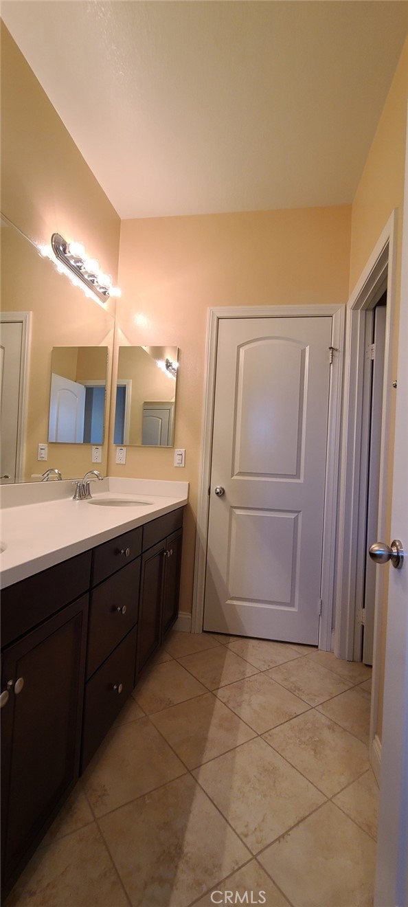 13209 Lima Drive Rancho Cucamonga, CA 91739 - Photo 18 of 25 a bathroom with a double vanity sink a mirror and a bathtub