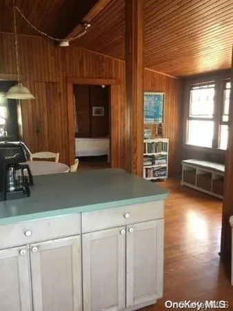 a kitchen with stainless steel appliances wooden floor and a refrigerator