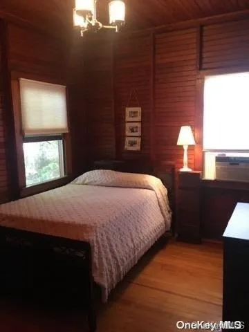 a bedroom with a bed and a lamp on dresser
