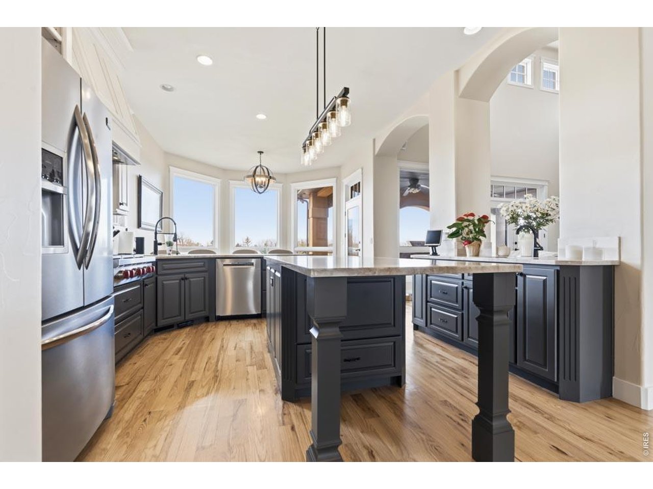 964 Riparian Way Fort Collins, CO 80524 - Photo 4 of 42 a kitchen with stainless steel appliances kitchen island granite countertop a refrigerator a sink dishwasher and a oven with wooden floor