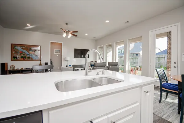 a kitchen with sink a large window and chairs