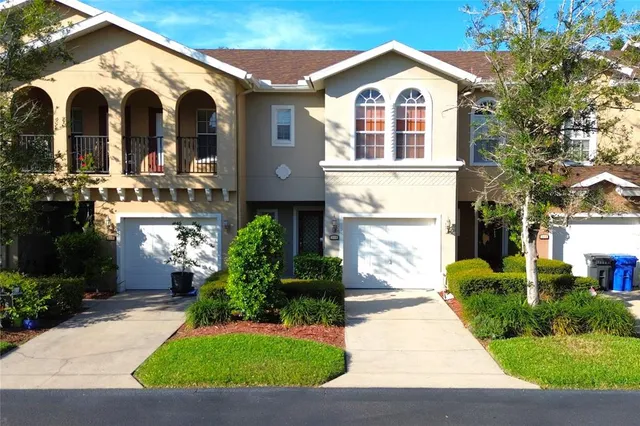 a view of a brick building with large windows and a yard in front of it
