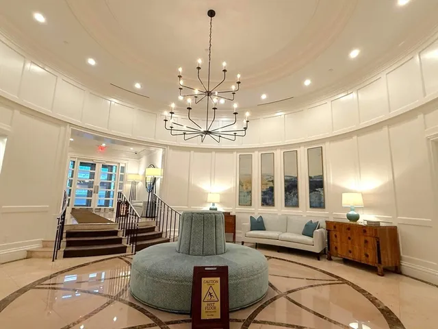 a living room with furniture chandelier and a view of kitchen