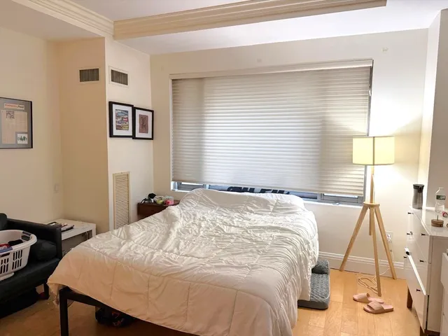 a bedroom with a bed and a flat tv screen on the dresser
