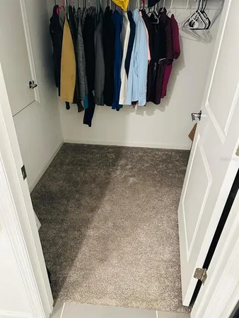 a view of walk in closet with clothes