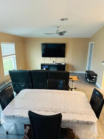a living room with furniture a flat screen tv and a window