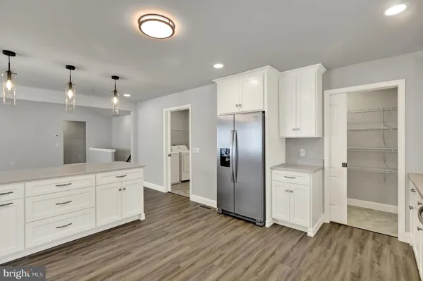 a large kitchen with a refrigerator and a sink