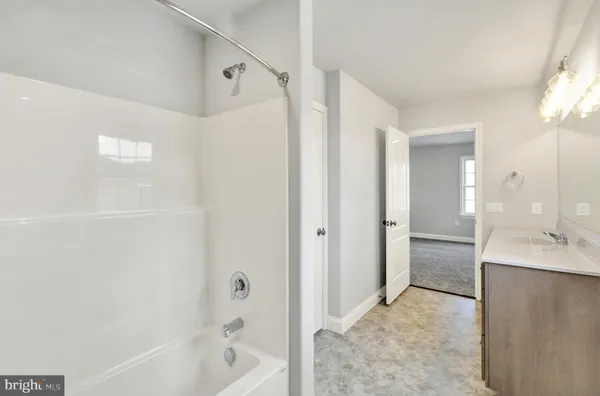 a bathroom with a bathtub shower and a sink