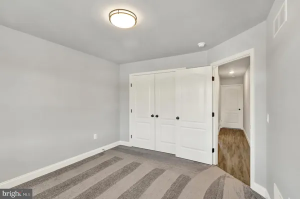 a view of a livingroom with wooden floor and bathroom
