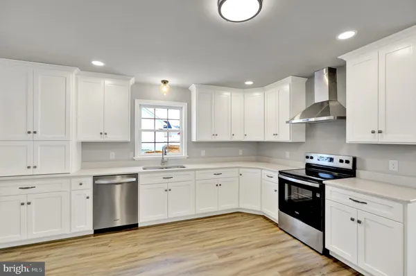 a kitchen with granite countertop white cabinets and white appliances