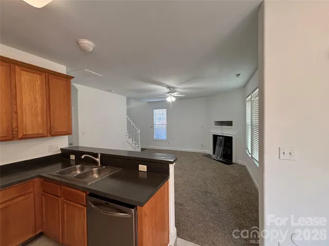 a kitchen with granite countertop a sink stove and cabinets